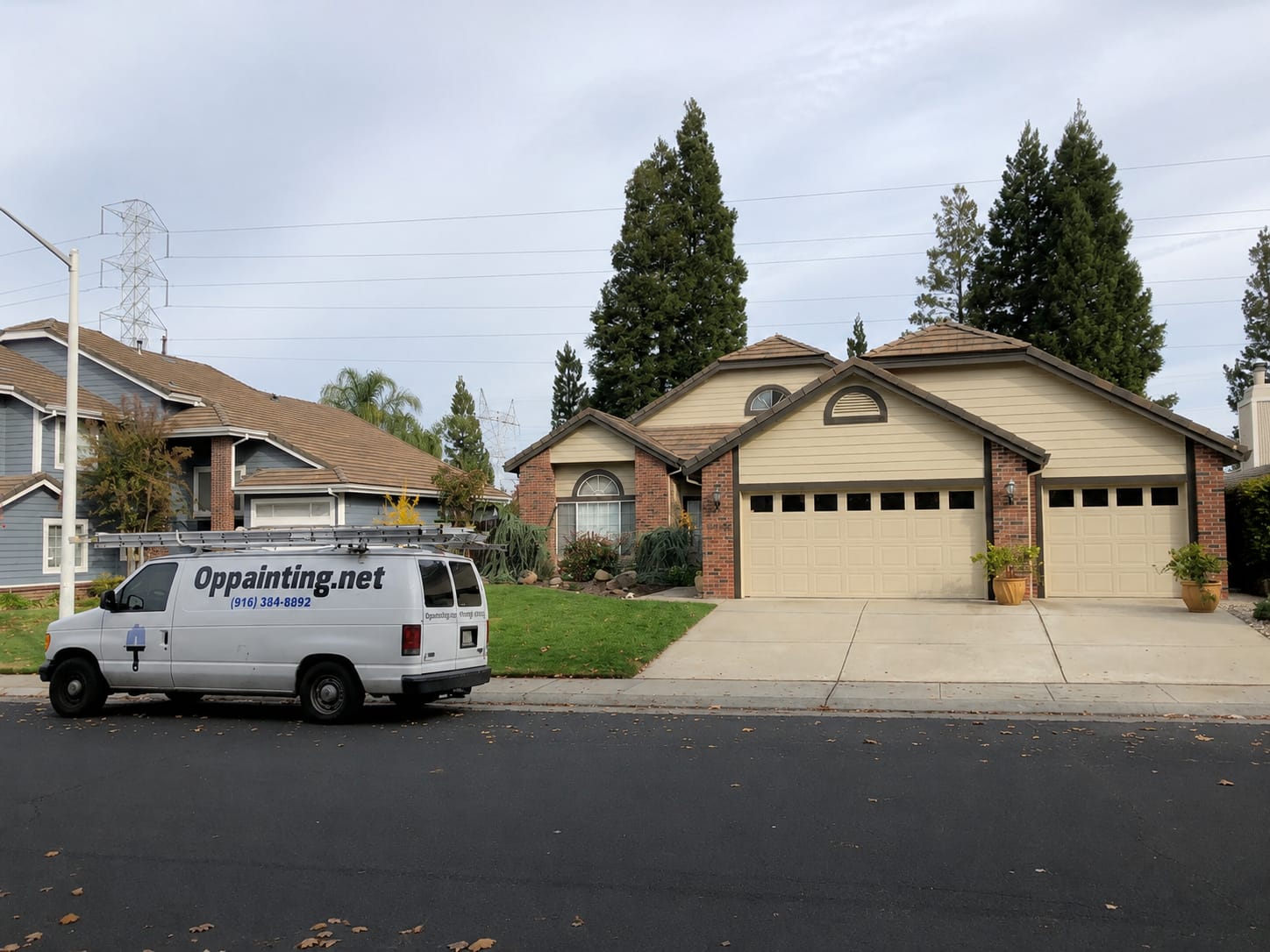 The same Roseville home after the repaint, with the siding, gable vents and garage doors finished in cream against the brick.