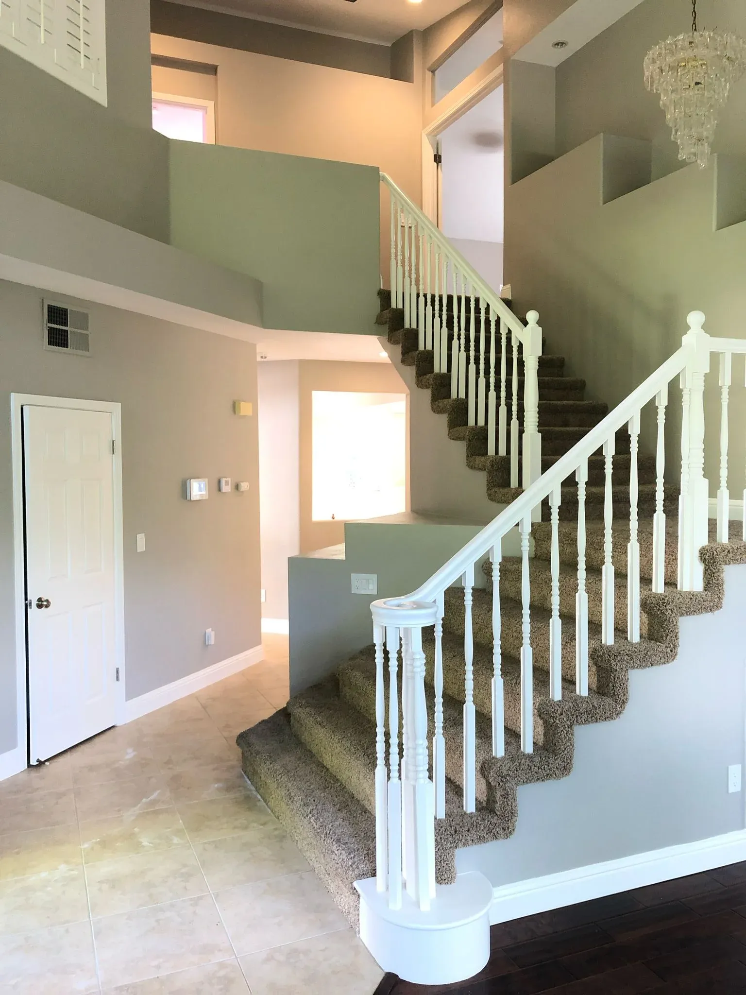 Modern Two-Story Foyer with Vaulted Ceiling and Sculpted Staircase