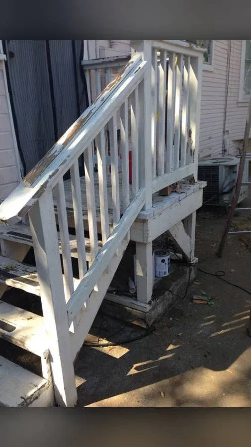 Weathered White Wooden Deck Stairs with Peeling Paint and Exposed Wood Base