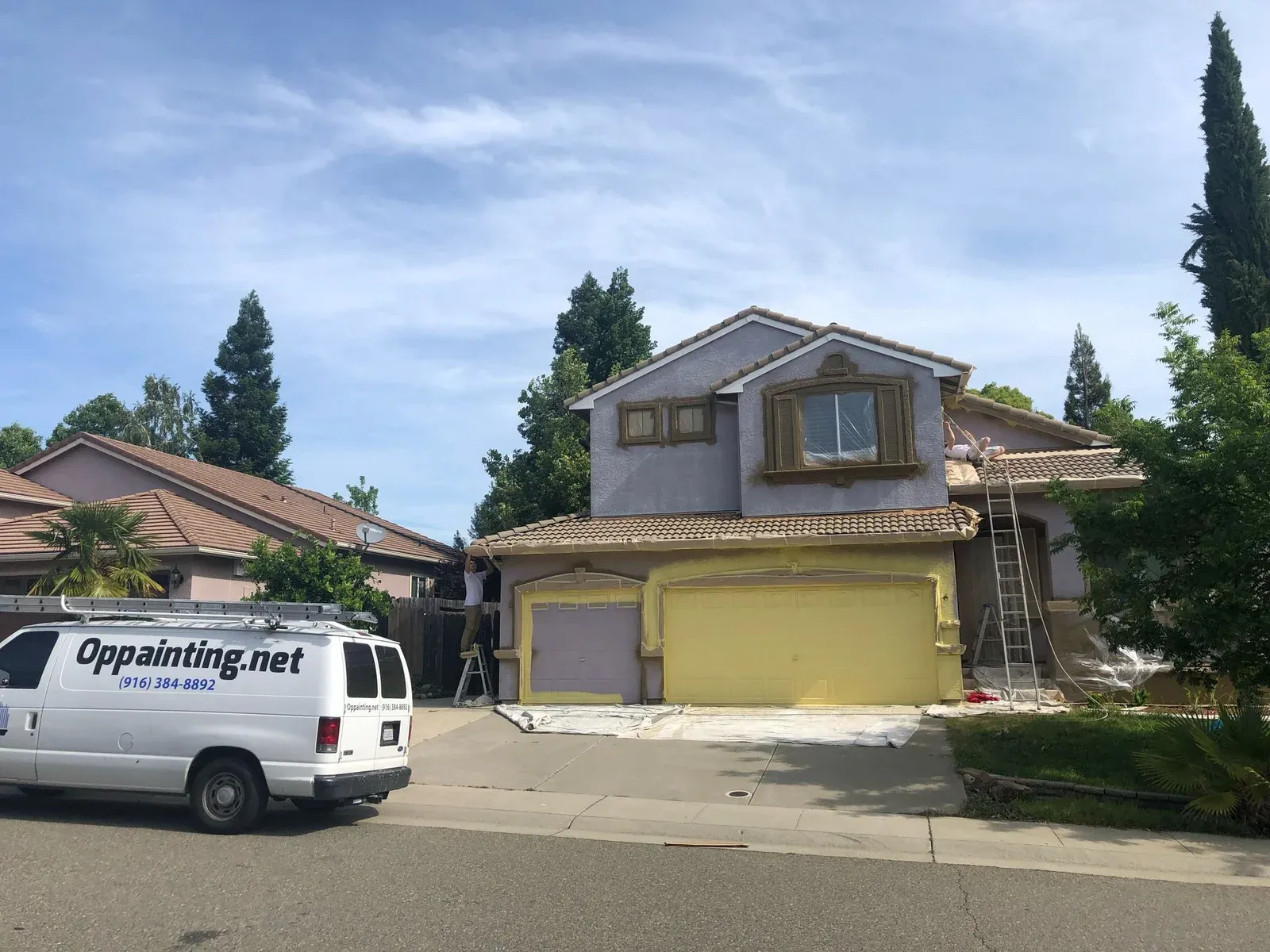 Residential House Undergoing Exterior Painting with Professional Service Van On-Site